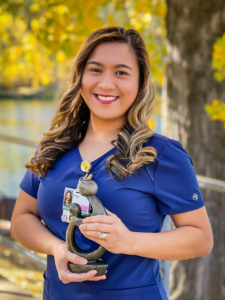 Registered Nurse outside holding DAISY Award