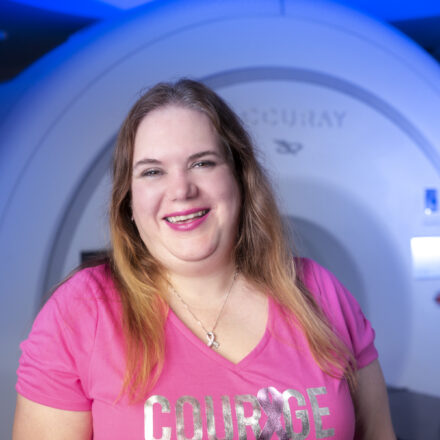 Woman smiling in front of medical imaging equipment