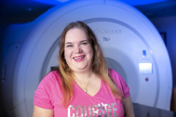 Woman smiling in front of medical imaging equipment