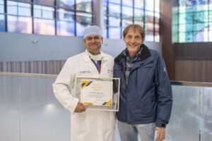 Dr. Mungara holding his award and posing with 