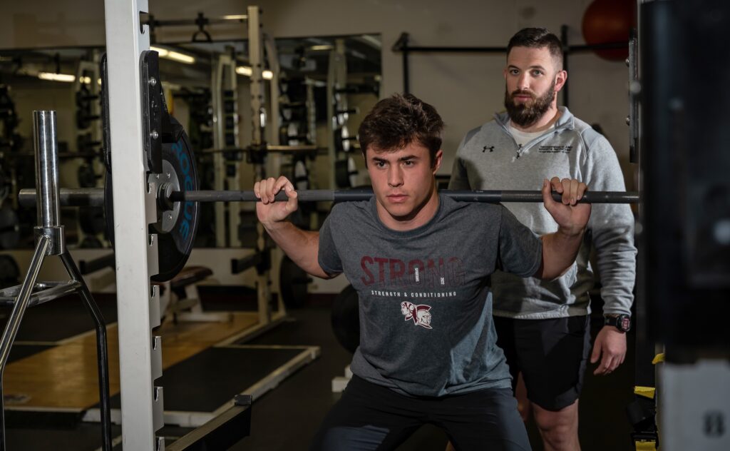 Strength and conditioning coach, Eric Santure, helps Spearfish High School runner Jaden Guthmiller train